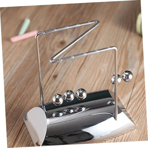 Z Shape Newtons Cradle Desk Toy For Home Office Decor with five silver balls on wooden desk, showcasing energy balance.