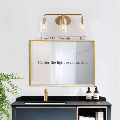 Three Light Gold Vanity Light With Seeded Glass Shades above bathroom mirror and sink, modern matte gold bathroom fixture