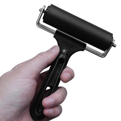 4 Inch Rubber Brayer Roller For Flooring Installations And Decking, Heavy Duty Glue Roller in hand showing black handle and steel frame