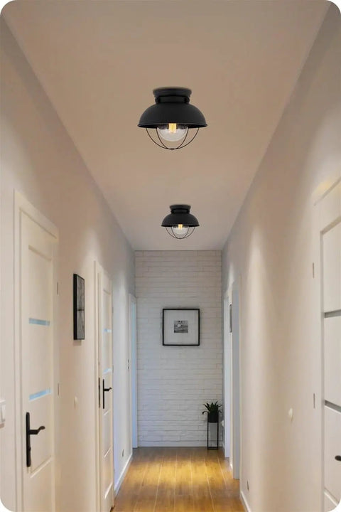 Farmhouse Nautical Flush Mount Ceiling Light With Seeded Glass Shade in hallway setting, matte black finish, removable cage visible.