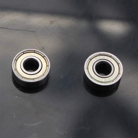 Close-up of two ABEC 7 608ZZ inline skate bearings, showcasing dual shielded steel construction for durability.