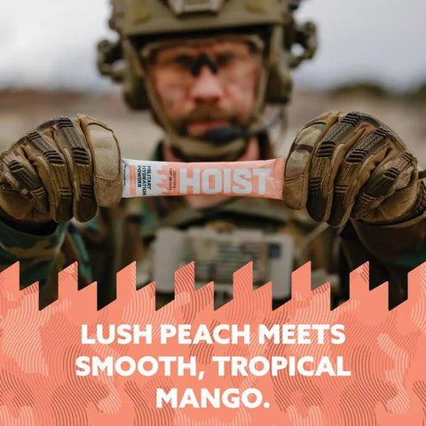 Sick Electrolyte Drink Mix Powder Sticks Loaded With Vital Minerals For Crushing Workouts And Fast Post Gym Recovery Peach Mango Flavor in soldier's hand.