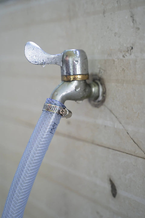 High Pressure Braided Clear PVC Tubing Three Quarter Inch ID 98 Feet With 10 Hose Clamps attached to metal faucet
