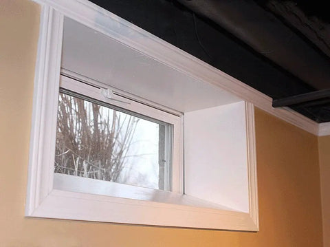 Vinyl Basement Hopper Window 32 By 18 White installed, showcasing heavy duty 3 inch mainframe and full screen coverage in a wall.