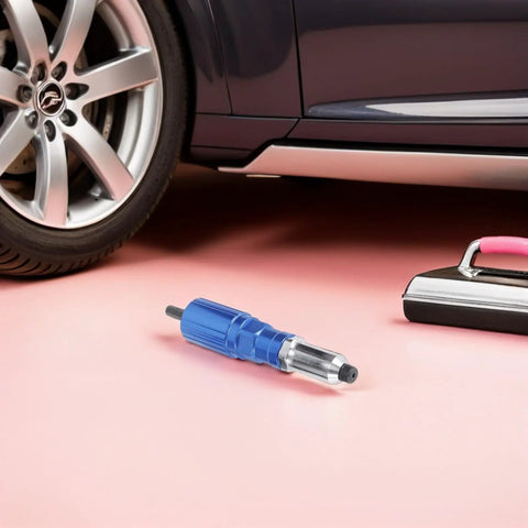 Electric Rivet Nut Tool Adapter Kit with Aluminum Alloy Converter Head on pink surface near car wheel.