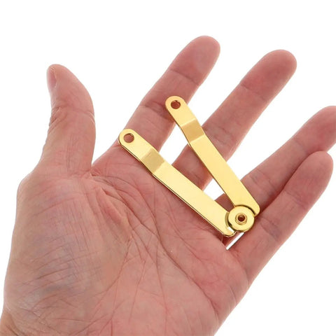 Gold Iron Lid Support Hinges For Small Boxes held in hand, showcasing the compact size and durable beefy iron sheet linkage design.