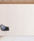 Peel And Stick Beige Waterproof Wallpaper Roll Thickened PVC Self Adhesive Wall Wrap For Bedrooms And Closets No Stress Fresh Look Oilproof Finish Smooth Home Vibe Upgrade applied on a minimalist wall beside a black chair.