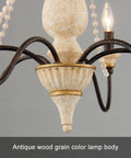 Close-up of distressed white wood finish on French Country Farmhouse Six Light Chandelier with wood bead accents for cozy homes.