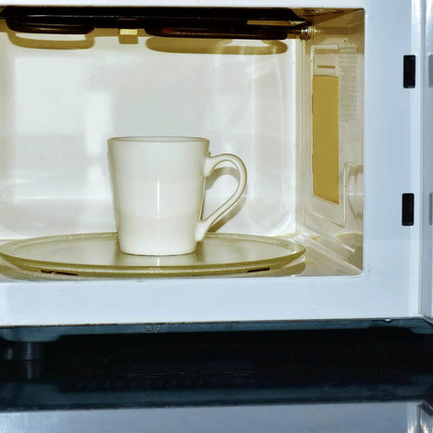 A mug inside a microwave with visible mica waveguide cover from the 4 Pc Waveguide Cover Replacement Kit With Scissors, 150Mm By 120Mm Mica Plates Sheets.