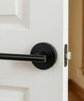 Black Passage Door Lever Set installed on white door, visible lever and strike plate, adjustable backset, modern home upgrade.