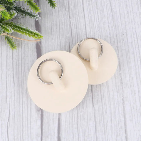 4pcs White Rubber Bathtub Stopper with Hanging Ring for Sink Drains, two stoppers with metal rings on a wooden surface.