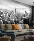 Black-and-white living room with New York City Skyline Canvas Wall Mural in background, self-adhesive peel and stick, modern urban decor.