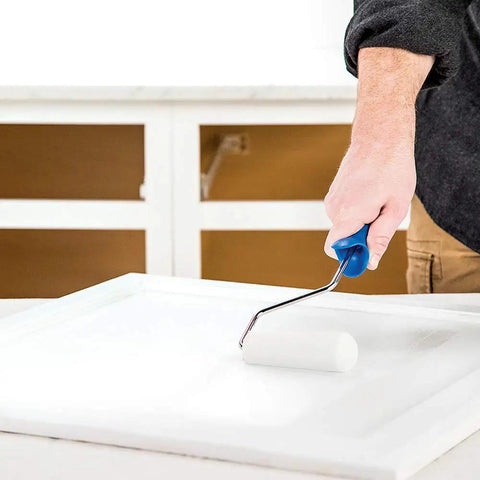 Applying Cabinet Coat Urethane Acrylic Satin Sheen Enamel Cabinet Paint White One Quart on kitchen cabinet door with a roller