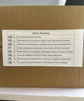 Cardboard box with multilingual safety warning label advising distance from fire sources.