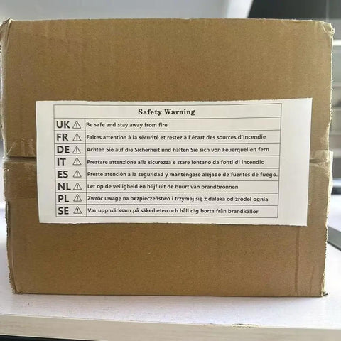 Safety warning label on a cardboard box in multiple languages, advising to keep away from fire.