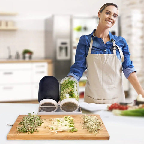 Woman using All In One Sprouting Jar Kit With Two Wide Mouth Mason Jars 316 Screen Sprout Lids Blackout Sleeves Tray And Stand For Growing Broccoli And Alfalfa At Home Seeds Not Included in kitchen.