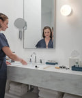 Woman using Flute High Arc Bathroom Faucet, 3-Hole 6-16 Inch Installation, WaterSense Labeled, Chrome Finish, in modern bathroom