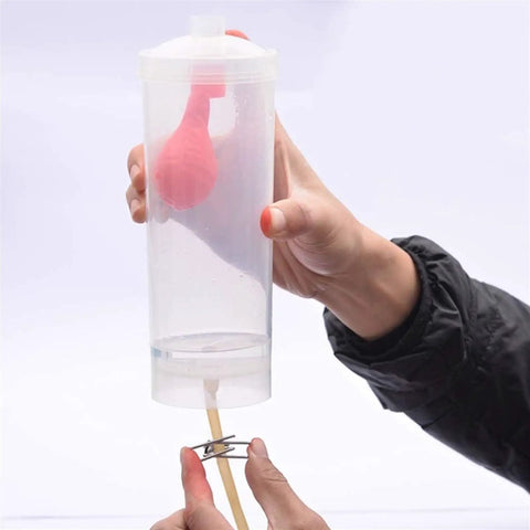 Hands On Physics Lab Kit For Liquid Pressure Depth Relationship, Pendulum Energy Conversion And Pulley System Mastery Through Real World Experiments showing a hand holding a clear container with rubber bulb inside.