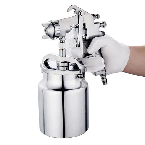 Hardcore Pro Level Pneumatic Spray Gun With Slick Adjustable Valve And Killer Stainless Steel Nozzle For Smooth Auto Paint Jobs Up To 1000 Ml Capacity tight antiskid grip held in a gloved hand.
