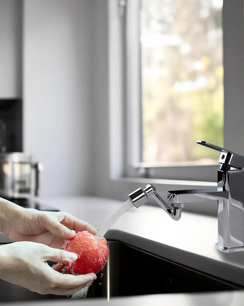 Hands holding a red apple under water from the Super Slick Chrome Faucet Extender with 1080 Degree Swivel Rotation.