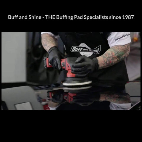 Person using polisher with microfiber pad set for car detailing on black surface