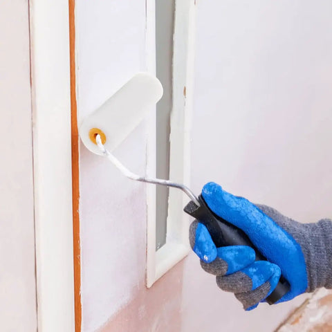 Hand holding a paint roller with Ten Pack Replacement Paint Roller Covers With Ultra Soft Low Density Foam Sponge Sleeves for wall painting.