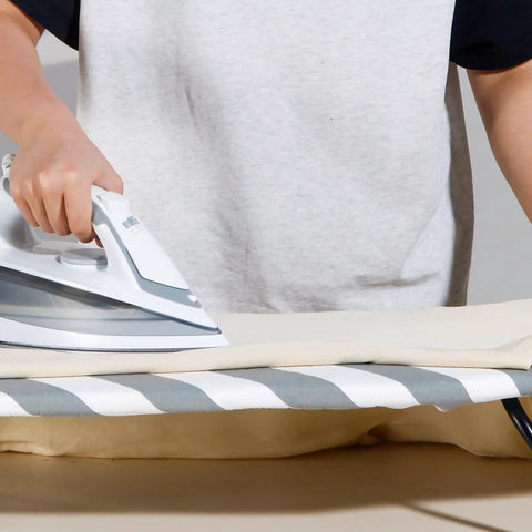 Person ironing on a Tiny Tabletop Ironing Board Cover And Pad Cotton Cover With No Fuss Extra Thick Padding That Resists Scorching