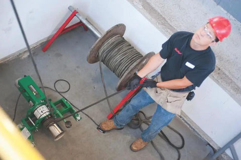 Heavy-Duty UT10-22 Puller for Cable and Wire Pulling in use on job site, worker using pro-grade tool, durable electrical hand tool.