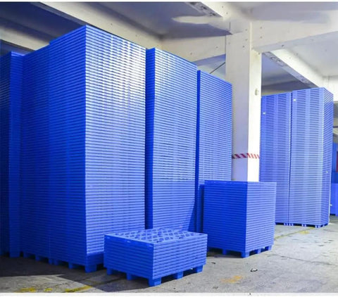 Stacks of blue Reusable Plastic Pallet System With Nestable Modular Trays And Grid Design For Wet Areas Like Kitchens And Garages.