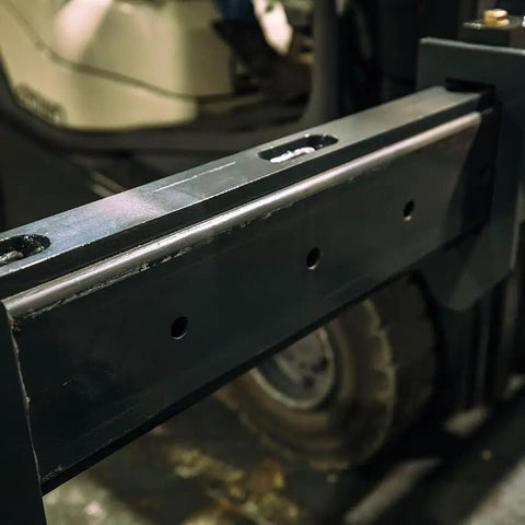 Top Shelf Adjustable Fork Spreader For Forklift And Telehandler close-up showing heavy-duty metal design and attachment points.