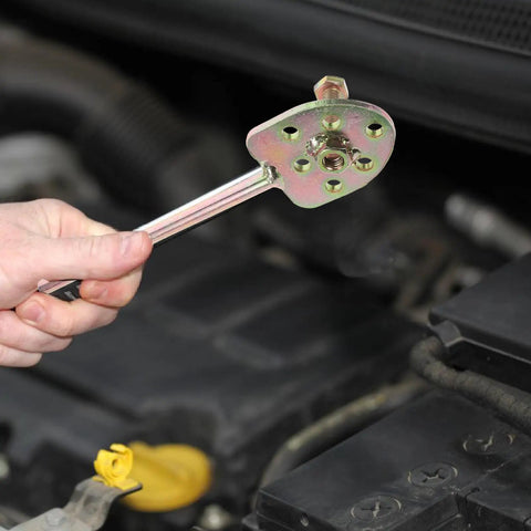 Holding a tool from the Auto AC Compressor Repair Tool Set 3 Piece Disassembly Kit for compressor removal under the hood.