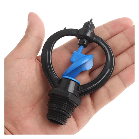 Hand holding a compact 360 Degree Rotary Garden Sprinkler Nozzle For 1/2 And 3/4 Inch Hoses made of ABS material, close-up view