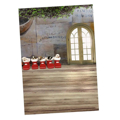 Holiday decorative setup with plush toys in red boots and a wooden door, set against a textured wall background.