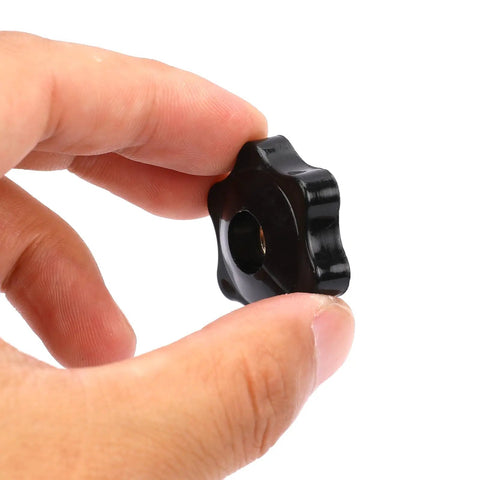 Hand holding a black 1/4-20 six point star knob with reinforced brass insert for workshop jigs and T track clamping.
