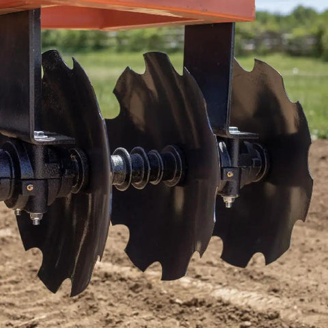 Close-up of 3 Point 6-Foot Notched Disc Harrow Plow Attachment for Cat 1 Tractors with 16-Inch Notched Discs in a field