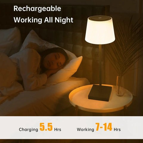 Black finish Cordless Rechargeable Table Lamp With USB Charging, Touch Dimmer, shown lit on bedside table in bedroom.