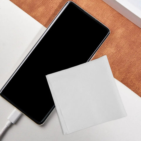 Top Shelf White Cleanroom Wiper Cloth For Flawless Camera Lenses Phone Screens Smart Watches And Eyeglasses Straight Up Dust Free Nano Microfiber on table next to phone.