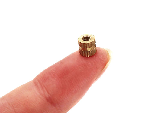 Close-up of a brass M3 knurled threaded insert from M3 Knurled Threaded Inserts Brass Heat Set Nuts Kit 300Pcs Assortment For Laptop.