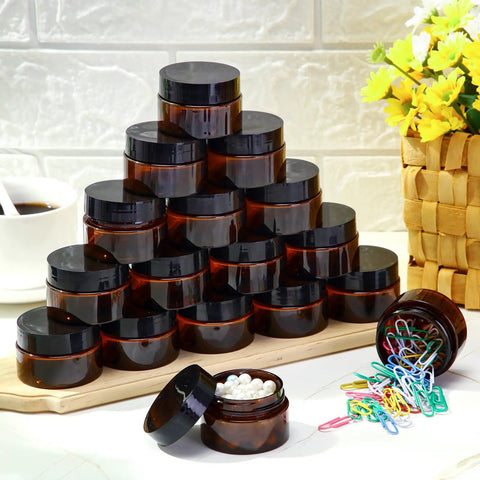 200 Piece 2 Oz Amber Plastic Cosmetic Jars Collection Round Travel Toiletry Containers With Secure Screw Top Lids organized on a table.