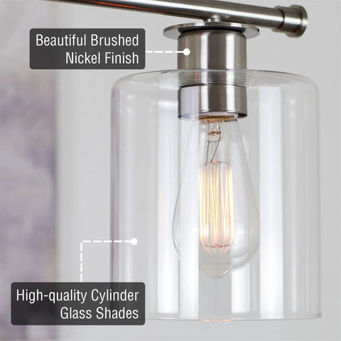 Close-up of brushed nickel fixture with clear glass shade from Three Light Kitchen Island Fixture With Clear Glass Cylinder Shades In Warm Brass Finish, Modern Industrial Farmhouse Pendant Lighting With Adjustable Hanging Height For Custom Height.