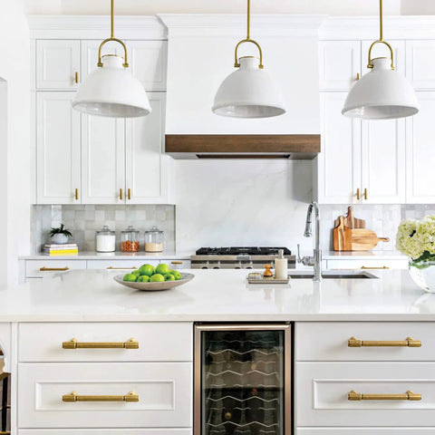Modern kitchen with Six Pack Antique Brass Drawer Pulls for Kitchen Cabinets and Dressers, sleek white cabinets, hanging lights.