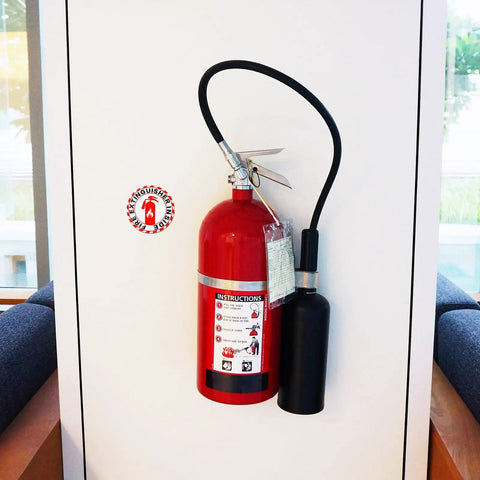 Glow In The Dark Fire Extinguisher Sign Labels 4 Pack 2.76 Inch Self Adhesive Waterproof Stickers installed on wall with fire extinguisher.