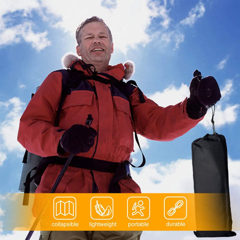 Man outdoors holding Ultralight Foldable Camping Side Table With Aluminum Build in carry bag under blue sky.