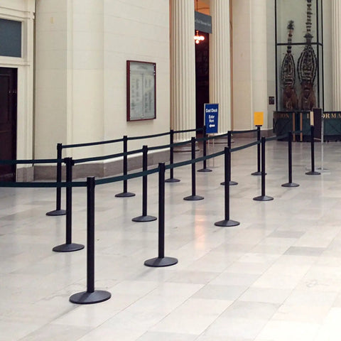 Commercial-Grade Stanchion Set 2-Pack With 10 Ft Retractable Belt Barrier Heavy Base Crowd Control Poles in a queue setup