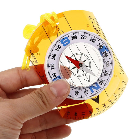 Hand holding orange Orienteering Compass For Hiking And Camping With Lanyard Multifunction Navigation Tool Lightweight Portable Trail Backpacking