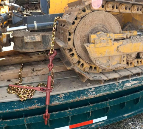 Heavy-Duty Grade 70 Transport Chain And Binder Kit securing equipment on a flatbed, showing lever-style binder in use