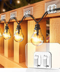 Rock Solid Outdoor String Light Hooks 100 Pack With Easy Peel Stick Adhesive No Drilling Or Damage Weather Proof Uv Resistant For Patio Deck Christmas Decor, string lights mounted on a wooden fence.