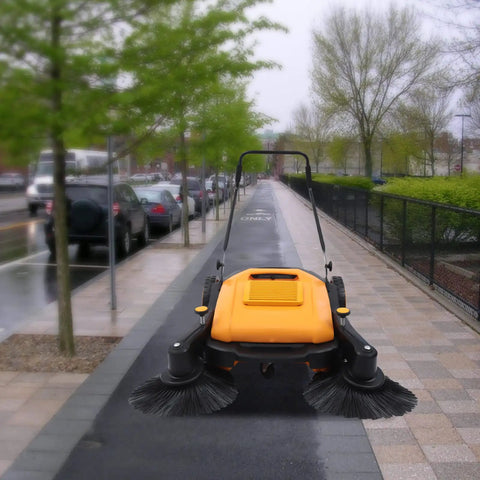 UILMLIO Manual Floor Sweeper With Foldable Handle, Motorless Design Saves Cash On Utility Bills on a wet sidewalk, showcasing its dual brushes.