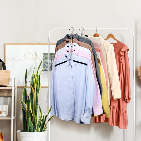 Multi Level Space Saving Closet Hangers With Plush Non Slip Foam Coating And Heavy Duty Black Steel Arms holding shirts on a rack.
