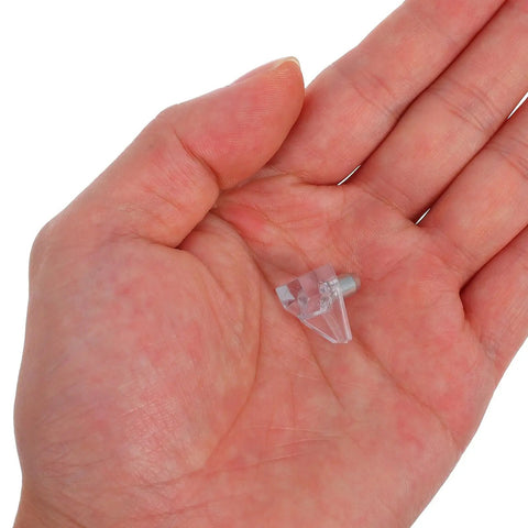 Hand holding Clear Plastic Shelf Support Pegs Set Of 100 Self Locking Pins For Cabinet Shelves No Fuss Install For Wardrobes Wine Cabinets